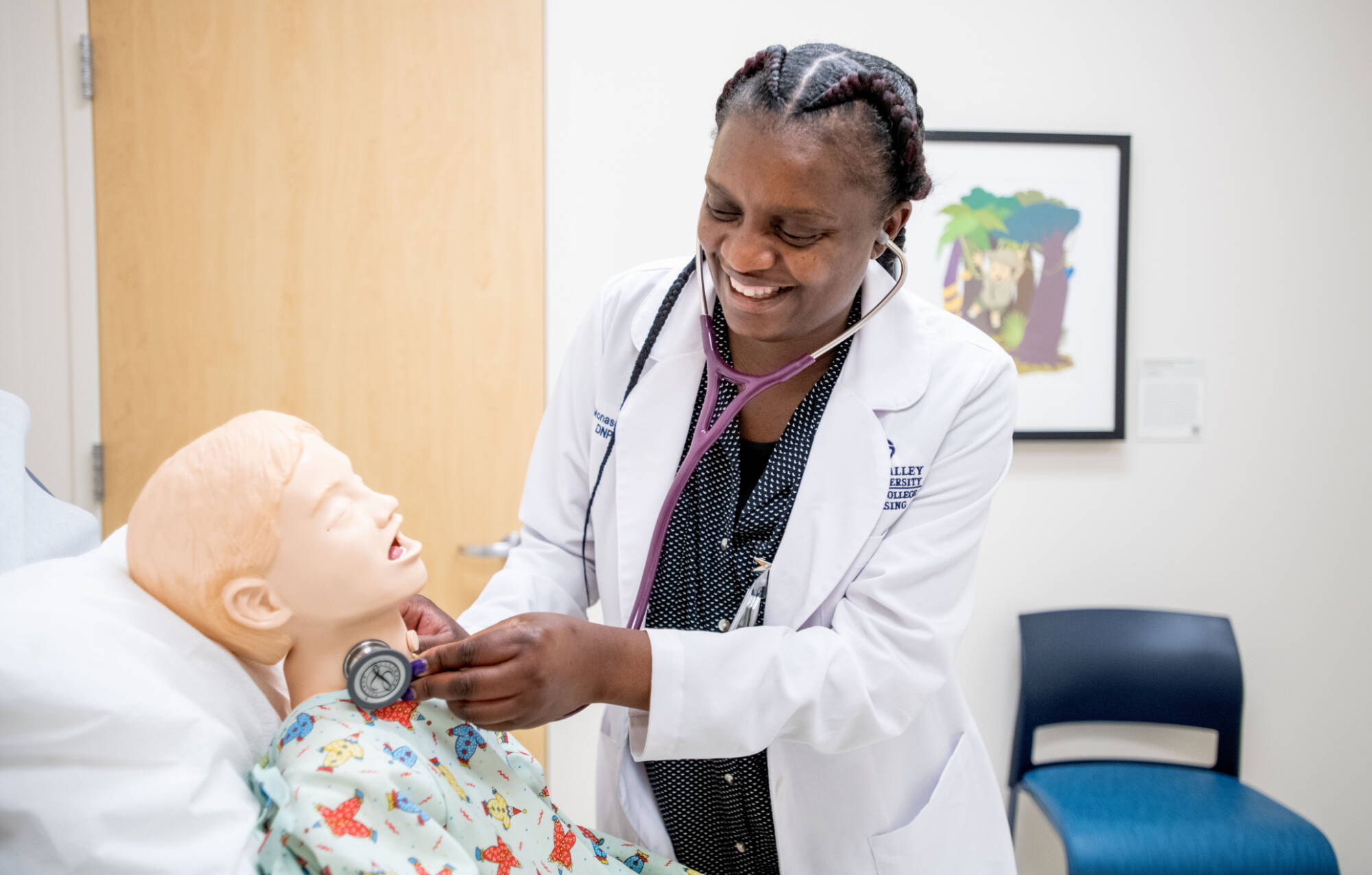 Nursing doctoral student, Monase Chibambo, assesses a manikin simulator in Grand Valley's Simulation Center.